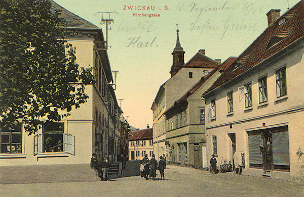This picture postcard shows the old Kostelní ulice (Church lane) at the market place. Whereas the houses on the right side including the old town-hall are standing till the present days the whole left side was demolished in 1978 in the course of the broadening ot the street so that the town received another deep incision.