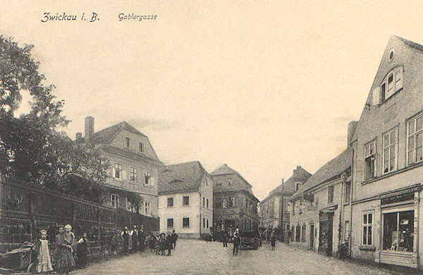 Diese Ansichtskarte zeigt die Häuser in der Mlýnská ulice (Mühlengasse) unter dem Marktplatz. Die meisten von ihnen stehen auch heute noch, nur das zweite Haus rechts wurde in der 2. Hälfte des 20. Jh. abgerissen.