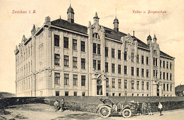 On this picture postcard from the years before World War One you see the monumental building of the primary and lower secondary schools. The motorcar before it possibly belongs to the then parish priest Bensch who used it to drive into the neighbouring villages where he held religious classes.