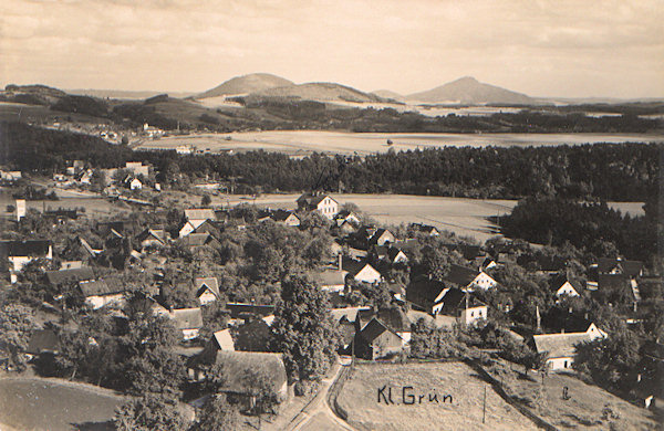 This picture postcard from the twenties of the 20th century shows the village of Drnovec as seen from the slope of the Zelený vrch hill from the point where in former times the restaurant „Schweizerhaus“ was standing. Behind the village there is the wooded Dutý kámen ridge, to the left behind it the church of Kunratice is seen and on the horizon there are the prominent hills Tlustec, Kovářský vrch and Ralsko.