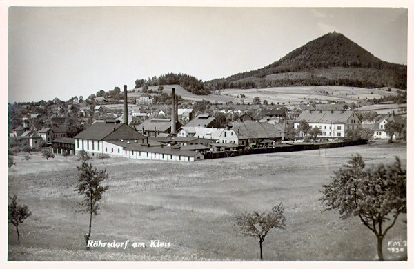 Na pohlednici z roku 1930 vidíme v popředí budovy sklářské huti Tereza, založené v roce 1873. Na obzoru je hora Klíč.