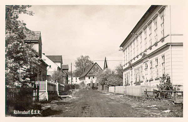 Na meziválečné pohlednici vidíme hlavní ulici v centru obce. Výstavná budova vpravo, ve které dnes sídlí pošta a obecní úřad, přišla při úpravách ve 2. polovině 20. století o svůj reprezentativní vzhled.