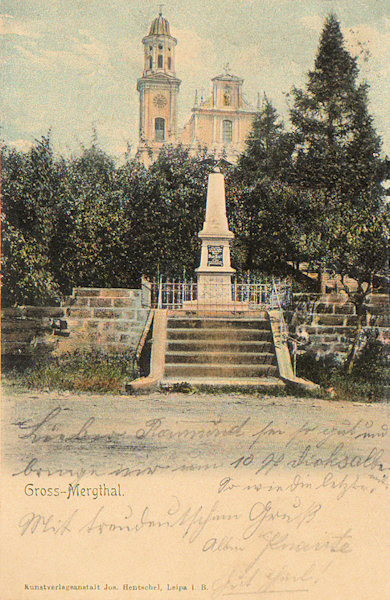Na této pohlednici vidíme bývalý památník obětem Prusko-rakouské války roku 1866 před kostelem sv. Máří Magdaleny. V roce 1933 byl renovován jako pomník padlým v 1. světové válce a po 2. světové válce byl odstraněn.