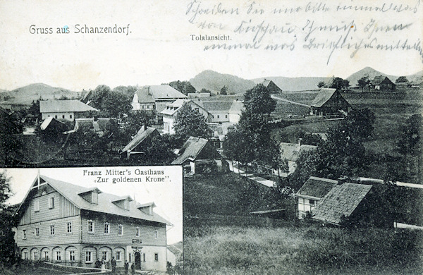 Auf dieser 1915 abgesandten Ansichtskarte sieht man ein Detail des Gasthauses „Zur goldenen Krone“, das man auch in der Mitte des grossen Bildes an den Dacherkern erkennen kann. Ein wenig dahinter ist das ehemalige Gasthaus „Zur deutschen Eiche“. Beide Gebäude und einige der anderen abgebildeten Häuser wurden nach 1945 abgerissen. Am Horizont wird das Bild von den Gipfeln (von links nach rechts) des Zelený vrch (Grünberg), Kulich (Gulichberg) und Klíč (Kleis) abgeschlossen.