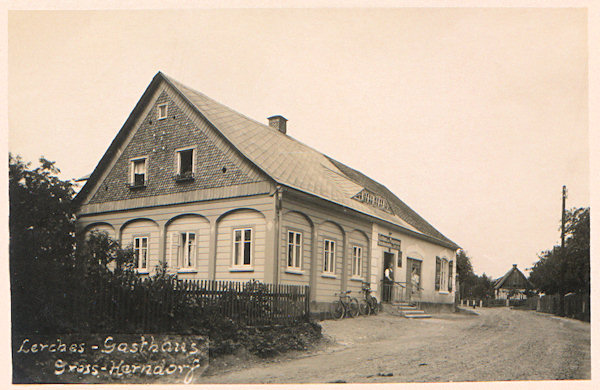 Na této pohlednici vidíme bývalý hostinec „U jitřního slunce“ (Zur Morgensonne) čp.77, který je poprvé zmiňován již v roce 1873. Hostinec a s ním spojený obchod provozoval až do roku 1945 Josef Lerche.