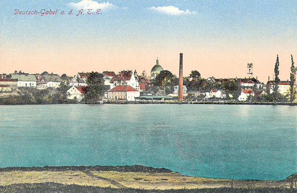 Pohlednice z roku 1918 zachycuje Jablonné ze západního břehu Zámeckého rybníka.