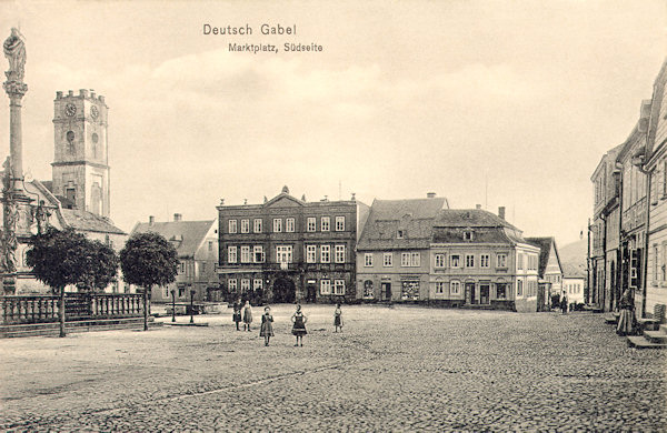 Tato pohlednice zachycuje jižní stranu náměstí, které dominuje budova tehdejšího hotelu „Adler“ (Orel). Vlevo vyčnívá věž bývalého měšťanského pivovaru.