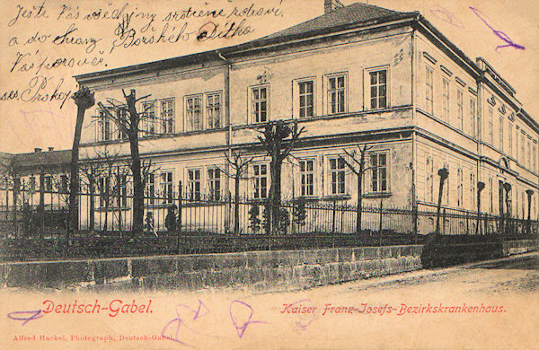 Tato pohlednice zachycuje bývalou Okresní nemocnici císaře Františka Josefa, jejíž budova v Tyršově ulici dnes slouží jako Léčebna dlouhodobě nemocných.