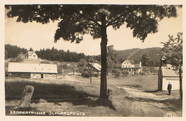 Die Ansichtskarte aus den 20er Jahren des 20. Jahrhunderts zeigt die Ortsmitte mit der Kapelle noch vor dem Bau der Strasse nach Hrádek nad Nisou (Grottau). Im Hintergrund sieht man das früher beliebte Hotel zum 'Steyrer Franzl'.