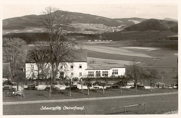 Auf dieser Ansichtskarte aus der Zeit zwischen beiden Weltkriegen sieht man das Gasthaus in Černá Louže mit seinem neueren Anbau, das schon damals 'Steyrer Franzl' genannt wurde. Im Hintergrund ist der Jeschkenkamm mit dem Velký Vápenný (Grosser Kalkberg), an dessen Fusse Jítrava (Pankratz) zu sehen ist.