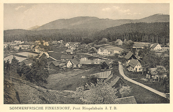 Diese Ansichtskarte aus der Zeit um 1920 zeigt die Ansicht der Gemeinde von Südosten. In Vordergrund sieht man die Strasse nach Černá Louže (Schwarzpfütz), den Hintergrund schliesst das bewaldete Massiv des Liščí Hora (Fuchsberg) mit dem Loupežnický vrch (Raubdschlossberg, rechts) ab.