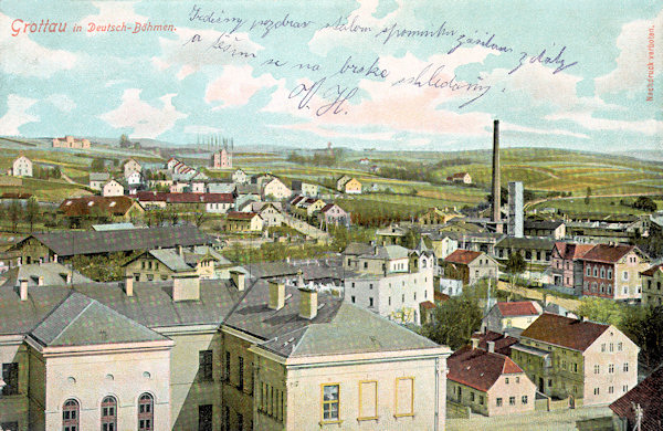 On this picture postcard from the beginning of the 20th century the eastern part of the town as seen from the tower of the Protestant church is shown. In the foreground there is the roof of the school, behind of it the long roof of the railway station warehouse and the houses standing along of the road to Liberec. On the left side on the horizon there is the front of the cemetery founded in 1898.