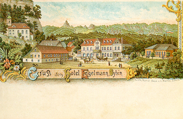 Tato pohlednice představuje bývalý hotel Engelmann v centru obce. Vlevo od něj vidíme hostinec Klosterhof a kostel pod hradním vrchem. Z lesů v pozadí vyčnívá špičatý Scharfenstein.