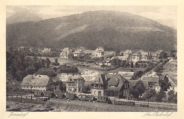 On this postcard from 1927 is a part of Jonsdorf with the station of the narrow-gauged railway. Behind the village there is the Buchberg and behind it in the horizon the Luž (Lausche)-hill.