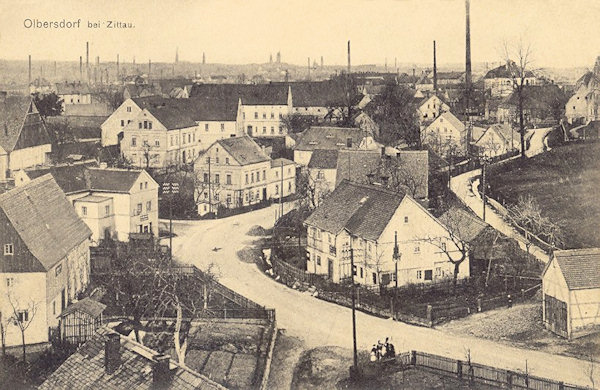 Pohlednice z roku 1911 zachycuje domy, stojící u hlavní ulice v dolní části obce. Na obzoru jsou patrné komíny a věže Žitavy.