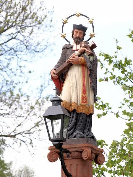 Socha sv. Jana Nepomuckého na vrcholu sloupu.