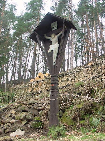 Polírův kříž vedle skalní kaple stával dříve na louce za vsí.