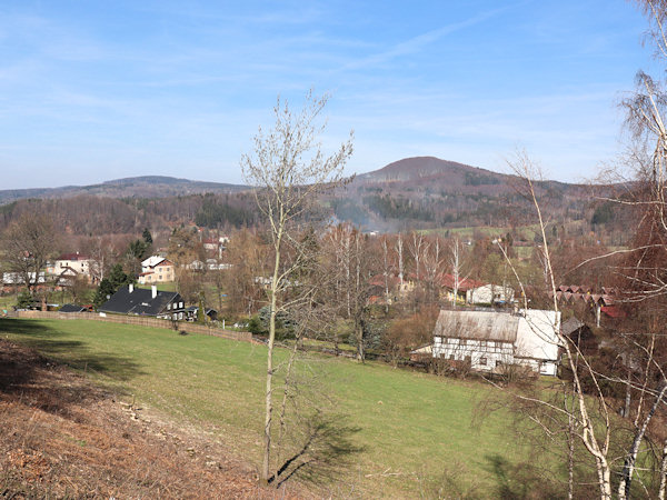 Pohled na osadu ze svahu Železného vrchu. V pozadí je vrch Plešivec.