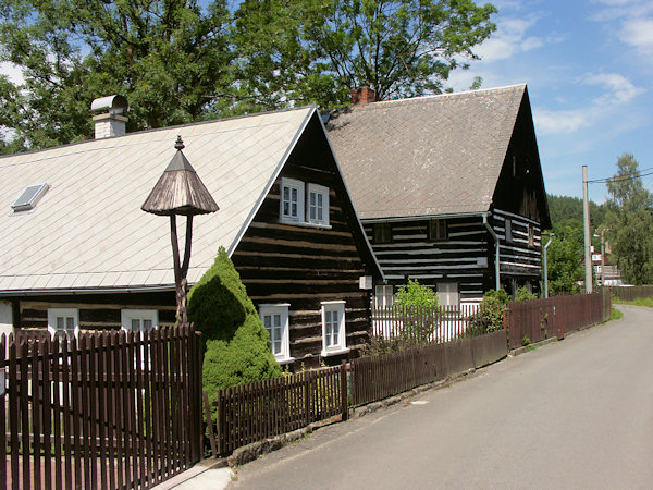 Roubené domy v dolní části vsi. V popředí je památkově chráněná chalupa č.p.113.