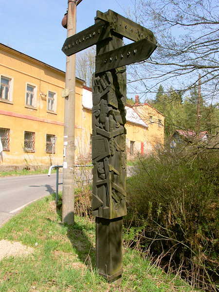 Dřevěný rozcestník na křižovatce je dílem akademického sochaře Josefa Fojtíka.
