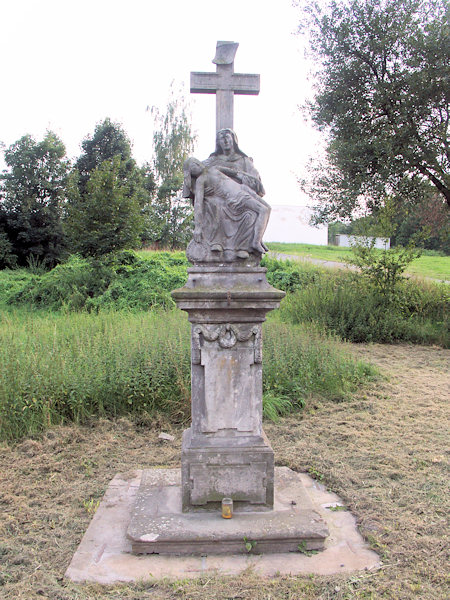 Eine denkmalgeschützte Pieta-Statue mit einem Kreuz.