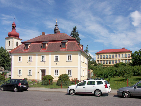 Fara s věží kostela sv. Bartoloměje a budovou školy v pozadí.