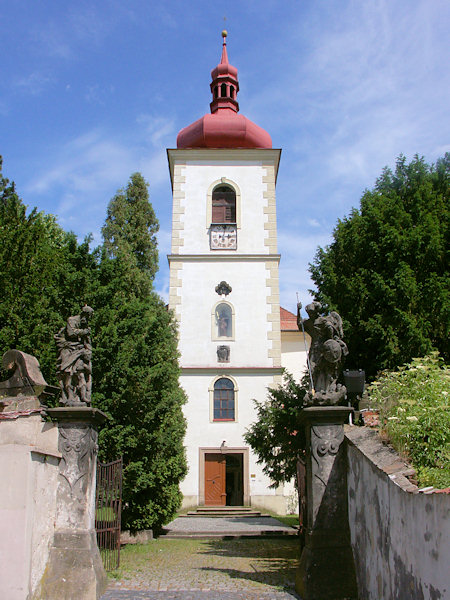 Průčelí kostela sv. Bartoloměje s dvojicí soch na vstupní bráně.
