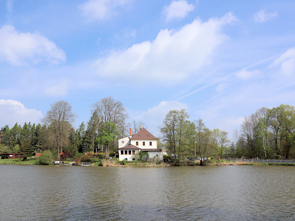 Blick auf den Teich mit einem Ferienhaus am Nordufer.