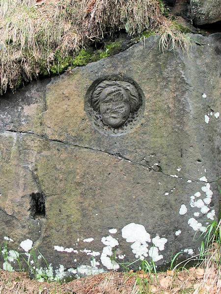 Poničený portrét na jedné ze skal ve starém lomu.