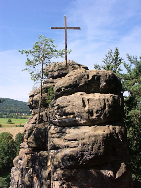 Dřevěný kříž na vrcholu skalní věže nad Božím hrobem.