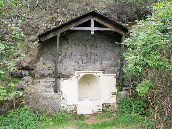 Volkstümliches Kreuzigungs-Relief an der Felswand nahe der Strasse von Trávník nach Mařenice.